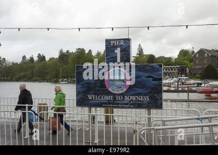 Zwei Erwachsene Menschen bei "Willkommen in Bowness" unterzeichnen auf dem Windermere Dampfer Pier in Bowness-on-Windermere auf einen dumpfen und regnerischen Tag. Stockfoto