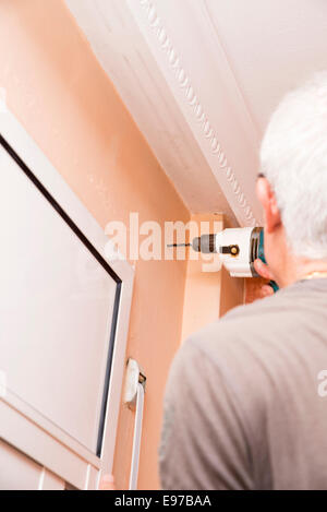 Arbeiter machen ein Loch in der Wand zu montieren Vorhänge Stockfoto