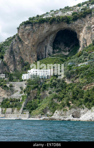 Eine große Höhle, Villen, Oliven und Zitronen auf den Klippen in der Nähe von Amalfi von einem Boot in der Bucht von Salerno im Mai Stockfoto