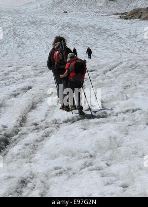 Bergführer führt seine jungen Kunden über einen Gletscher Gletscherspalte abgedeckt Stockfoto