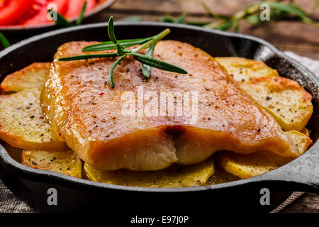 Gebackenes Fischfilet mit Kartoffeln in einer Pfanne erhitzen Stockfoto