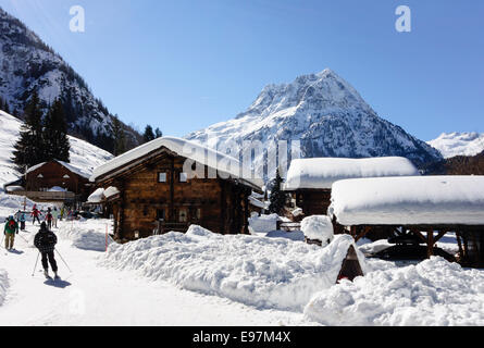 Skifahrer auf Schneehang nähert sich kleine Bergdorf Resort von Vallorcine im Tal von Chamonix, Haute Savoie Rhone-Alpes, Frankreich Stockfoto