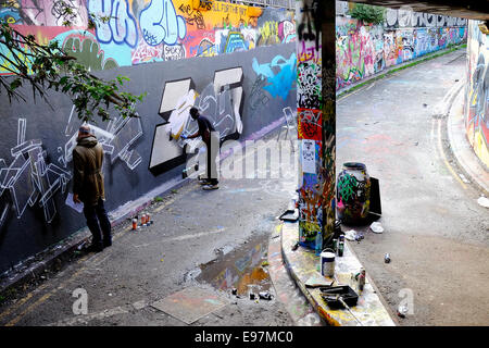 Graffiti-Künstler Dekoration einer Wand in Leake Street in Waterloo. Stockfoto