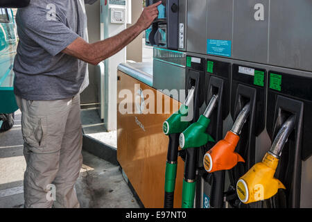 Mann, die Auswahl der Kraftstoffpumpe an Total Tankstelle für das Betanken seines Autos Stockfoto