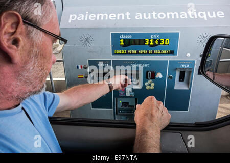 Fahrer im Auto bezahlen mit Kreditkarte an Automatik / elektronische Mautstelle Sammlung auf der französischen Autobahn Stockfoto