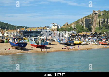 Schwimmen und Sonnenbaden am Strand von Hastings stade vor den Trawlern und der Hastings Contemporary Art Gallery, East Sussex, Großbritannien Stockfoto