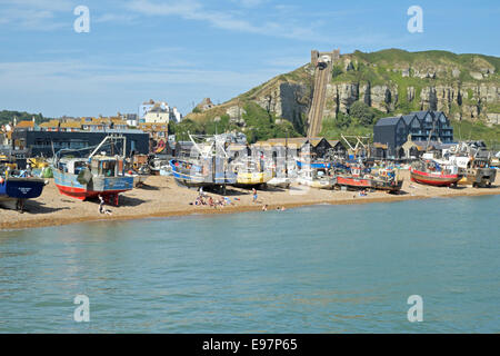 Menschen schwimmen und Sonnenbaden auf Hastings Stade Strand vor der Flotte von Fischkuttern und den Jerwood Kunst Galerie East Sussex England GB UK Stockfoto