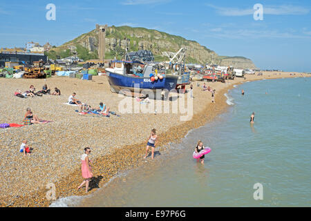 Menschen schwimmen und Sonnenbaden am Strand von Hastings Stade Fischer vor der Trawler, East Sussex, England, GB, UK Stockfoto