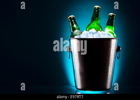 Bierflaschen im Eiskübel auf farbigem Hintergrund isoliert Stockfoto