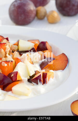 Obstsalat mit frischen Pflaumen, Äpfel und Haselnüsse Stockfoto