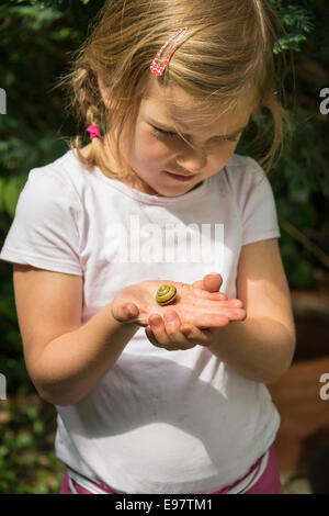 Kleines Mädchen halten Garten Schnecke in Händen Stockfoto