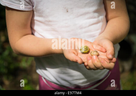 Kleines Mädchen Garten Schnecken in den Händen halten Stockfoto