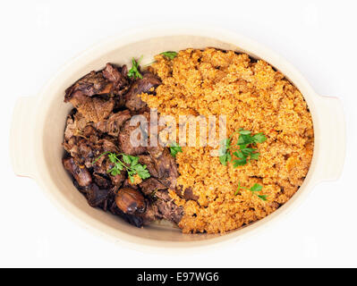 türkischer Lammbraten, Kuzu Tandir mit Bulgur-Pilaw in eine Servierschüssel geben, Nahaufnahme Stockfoto