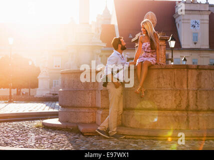 Junges Paar dating und flirten mit Brunnen in der Stadt Stockfoto