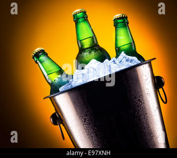 Bierflaschen im Eiskübel auf farbigem Hintergrund isoliert Stockfoto