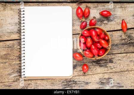 Waldbeeren mit leeren Notizbuch auf Holztisch. Rezept oder Menü Hintergrund Stockfoto