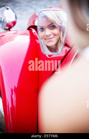 Junge Frau, Blick in den Rückspiegel des Autos Stockfoto