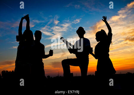 Junge Menschen tanzen und Spaß bei Sonnenuntergang Stockfoto