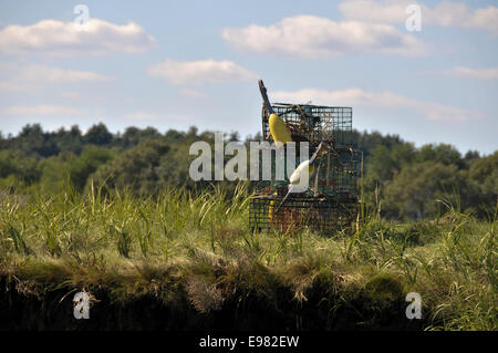 A auf sonnigen März Flussufer gibt es drei gestapelte Hummer fallen zwei Bojen an interessante Winkel befestigt. Es ist sonnig Szene Stockfoto