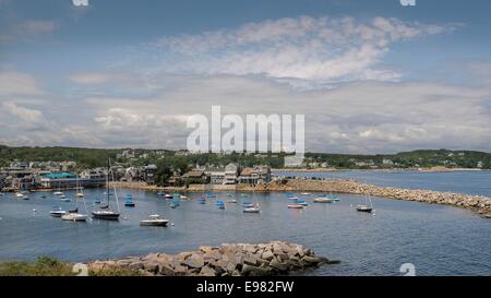 Blick nach unten in Rockport Bay gefüllt verschiedener Größe Sportboote langen steinernen Wellenbrecher. Grüne Hügel stellen Gebäude Stockfoto