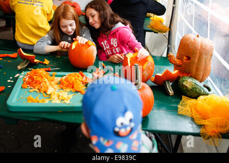 Berlin, Deutschland. 21. Oktober 2014. Kinder machen Kürbis Laternen während der Kürbis Jahresausstellung in Klaistow, südlich von Berlin, Deutschland, am 21. Oktober 2014. Die Ausstellung wird dauert bis 2. November, mit über 100.000 Kürbisse in fast 450 verschiedene Sorten auf dem Display. Bildnachweis: Zhang Fan/Xinhua/Alamy Live-Nachrichten Stockfoto