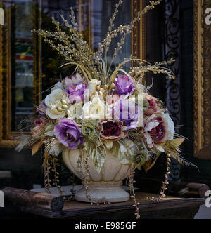 Künstliche Blumen. Die Fenster der Hotelrezeption sind in einem klassischen Stil wie „Stillleben“ gehalten. Stockfoto