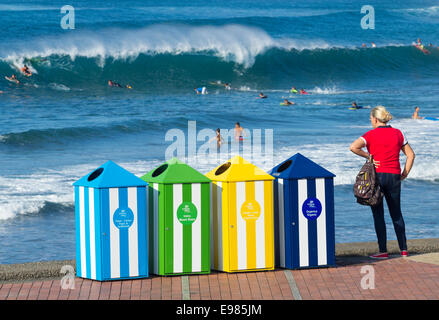 Recycling-Behälter am Las Canteras Strand bei Surfern im Hintergrund. Las Palmas, Gran Canaria, Kanarische Inseln, Spanien Stockfoto