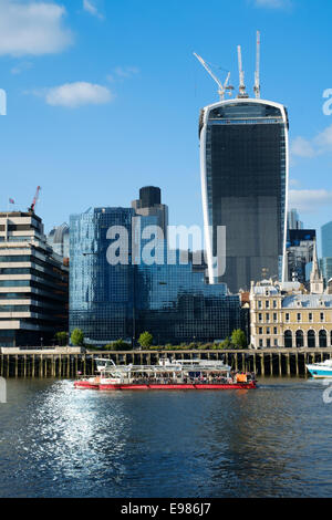 Architektur von London Stadt an der Themse vor Hintergrund eines blauen Himmels und mit Boot im Vordergrund Stockfoto