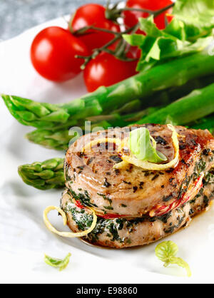 Sirloin-Steak für einen Schweinebraten und Spargel und Tomaten. Frischfleisch Mahlzeit Menü Stockfoto