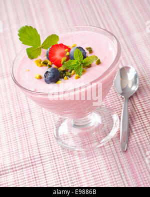 Kalte Beeren serviert in einer Glasschale mit Erdbeer-Sahne und Blaubeeren Richtfest. Stockfoto