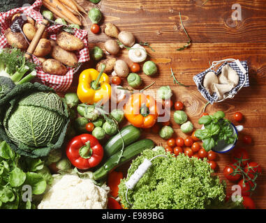 Draufsicht auf eine köstliche Auswahl an Bauernhof frisches Gemüse, Kräuter und Pilze ausgebreitet auf einem rustikalen Holztisch Stockfoto