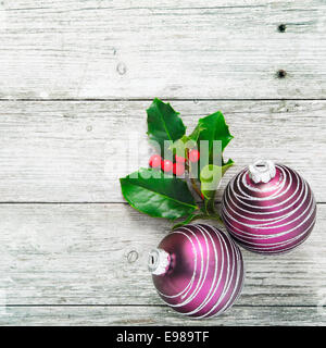 Rustikale Weihnachten Hintergrund mit dekorativen Holly und Kugeln auf Woodgrain Struktur weiß lackiert Bretter im quadratischen Format mit Exemplar Stockfoto