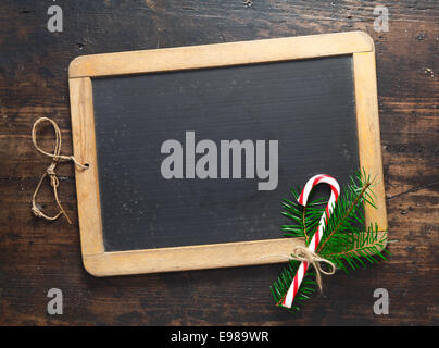 Kleine leere Holz gerahmten Tafel mit einem festlichen Zuckerstange und grün für Ihre saisonalen Nachricht für Weihnachten oder Neujahr Stockfoto