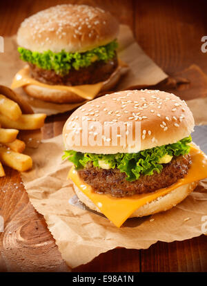 Zwei Hamburger und Pommes Frites auf braunem Papier Stockfoto