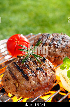 Bruststück Burger auf den Grill Pfanne mit offenen Flammen Stockfoto