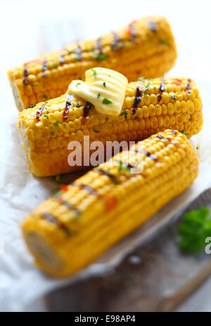 Drei Stücke von Maiskolben. Die mittlere hat ein Stückchen Butter drauf. Konzentrieren Sie sich auf der Mitte ein mit einer kurzen Tiefe des Feldes. Stockfoto