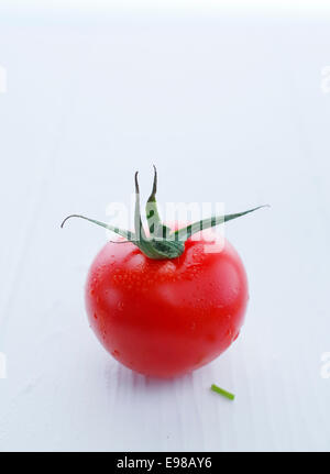 Wunderschöne rote Tomate mit Stiel, geringe Schärfentiefe gegen White erschossen. Stockfoto