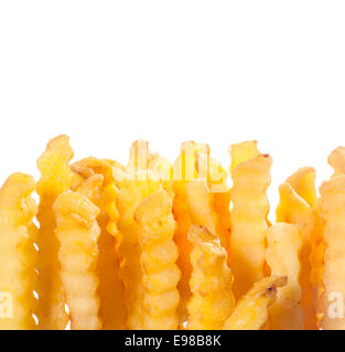 Crinkle schneiden wellig tief gebratene goldene Kartoffel-Chips für eine ungesunde leckerer Snack, Nahaufnahme, isoliert auf weiss mit Exemplar Stockfoto