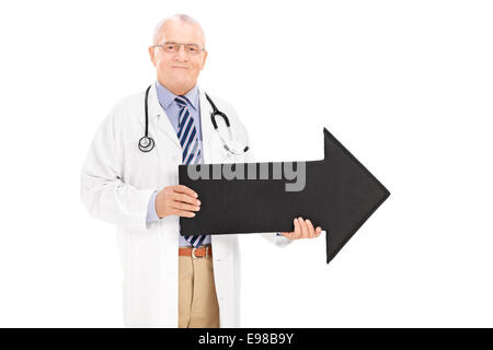 Reife Arzt hält einen schwarzen Pfeil rechts isoliert auf weißem Hintergrund Stockfoto