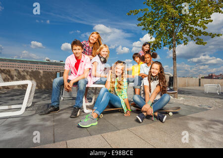 Kinder sitzen zusammen auf Stühlen mit skateboards Stockfoto