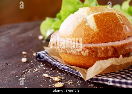 Herzhafte dicke Scheibe eine traditionelle deutsche Hackbraten auf einem frisch knackig knusprigen Rollen in einer Landhausküche Stockfoto