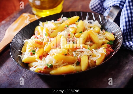 Gebratene fingerförmige goldene Kartoffel Dumplingsand Nudeln, traditionelle deutsche Küche, serviert in einer Pfanne, Nahaufnahme Stockfoto