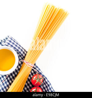 Ungekochte Spaghetti mit Tomaten und Olivenöl auf ein frisches blau und weiß liegend überprüft Serviette auf einem weißen Hintergrund mit Exemplar, Draufsicht Stockfoto