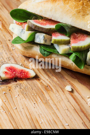 Herzhaft frisch gebacken Roll gefüllt mit gewürfelten Feigen, Blattspinat und salzig Blauschimmelkäse für einen leckeren gesunden Mittagsimbiss Stockfoto