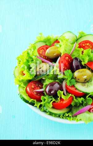 Teller mit frischen gemischten Salat mit Oliven, knackigen grünen Salat, Tomaten und Gurken für eine gesunde kalorienarme Mahlzeit Stockfoto