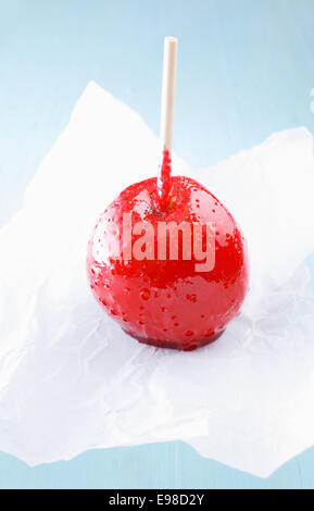 Köstliche Kindheit Süßigkeiten oder Taffy Apple in einem bunten harter roter Zucker Sirup steht auf zerknittertes Papier beschichtet Stockfoto