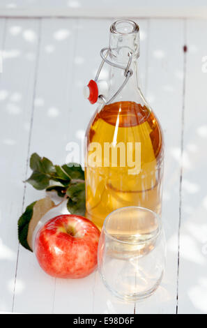 Flasche gesunden frischgepressten Apfelsaft mit einem köstlichen reifen roten frischen Apfel und leeres Glas warten um bedient zu werden Stockfoto