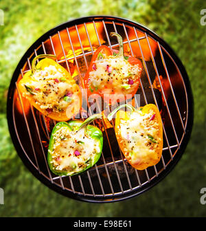 Ansicht von oben bunt rot, grün und gelb gefüllte zombis pikante Paprika Grillen auf einem BBQ mit glühend heißen Kohlen Stockfoto
