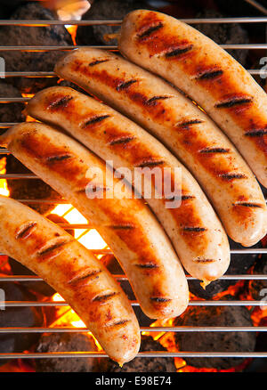 Reihe von leckeren gebräunt gebratene Schweine- und Rindfleisch Würstchen über glühende Kohlen auf dem Grill Feuer kochen, großaufnahme Draufsicht Stockfoto