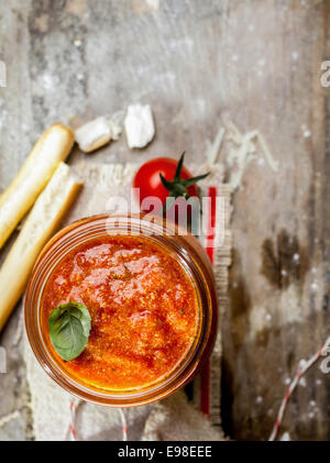 Draufsicht auf ein Glas heiße würzige Tomate lustvoll mit Grassini oder italienischen Brot-Sticks auf trashigen rustikalen hölzernen Hintergrund mit Exemplar Stockfoto